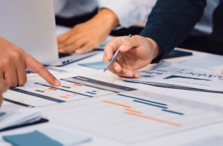 Diverse group of professionals engaged in a productive business meeting, analysing financial and strategic information, representing cost-effective mobility programme planning and decision-making.