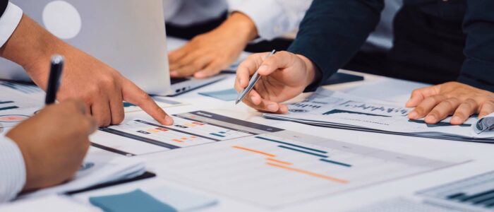 Diverse group of professionals engaged in a productive business meeting, analysing financial and strategic information, representing cost-effective mobility programme planning and decision-making.