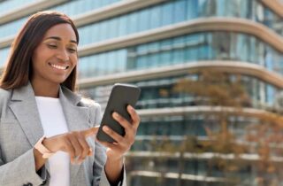 African businesswoman using a mobile phone for digital financial transactions, representing Kenya’s mobile money ecosystem and financial innovation.